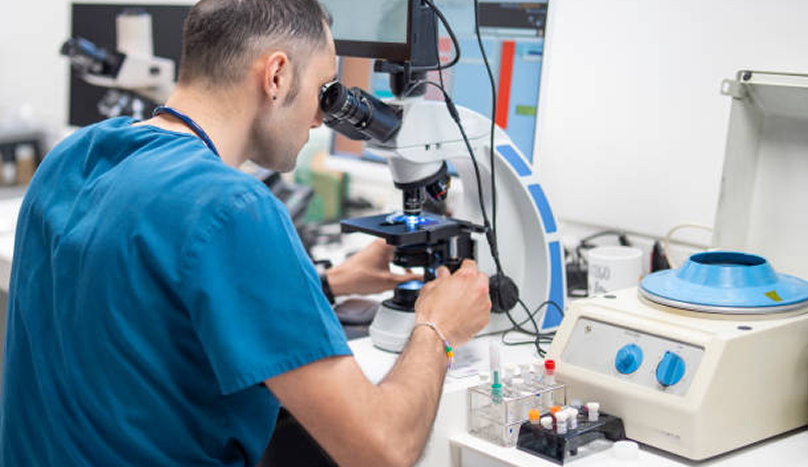 Veterinarian analyzing samples under a microscope in a laboratory.png